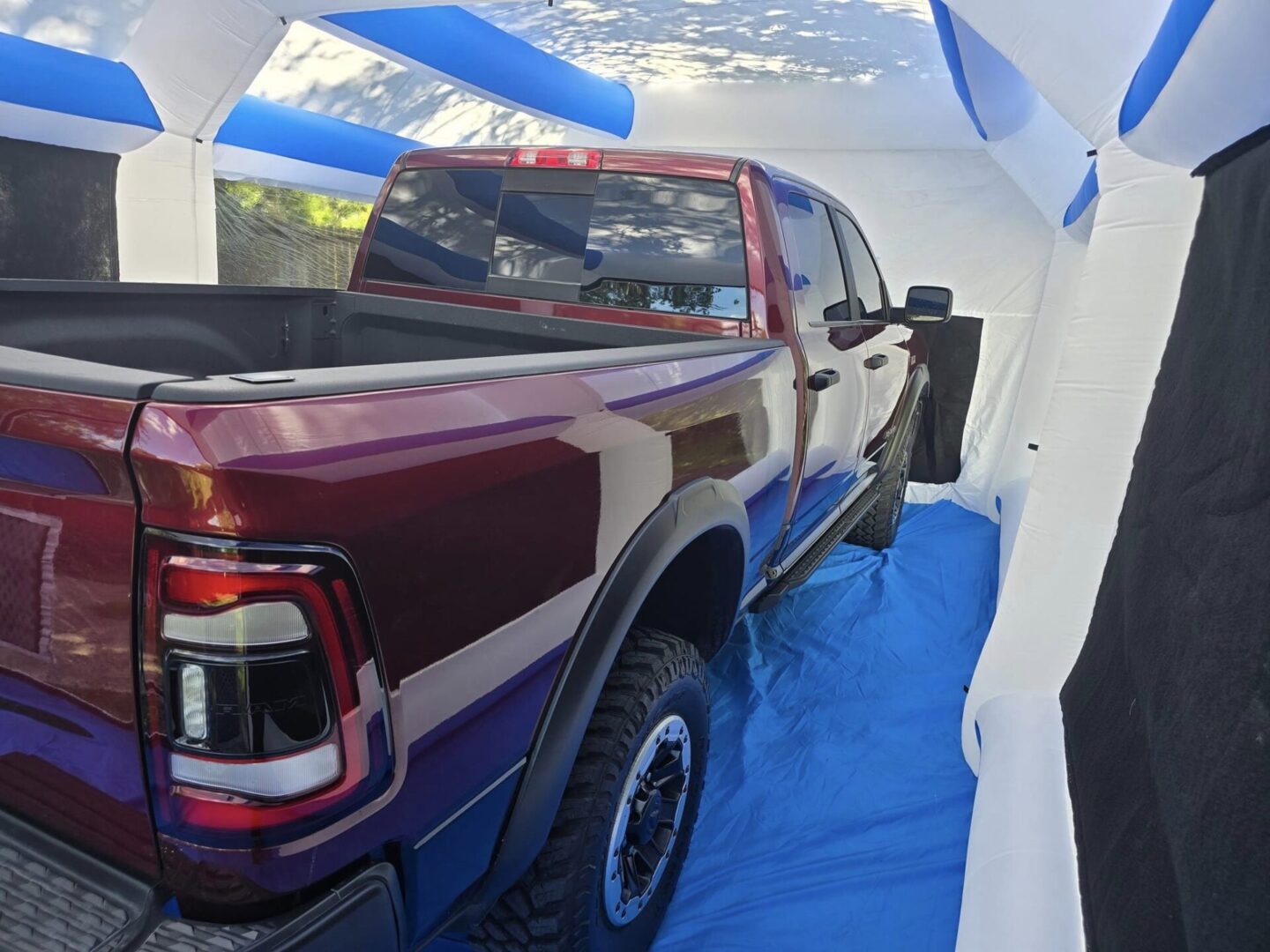 A truck is parked in the back of an inflatable tent.