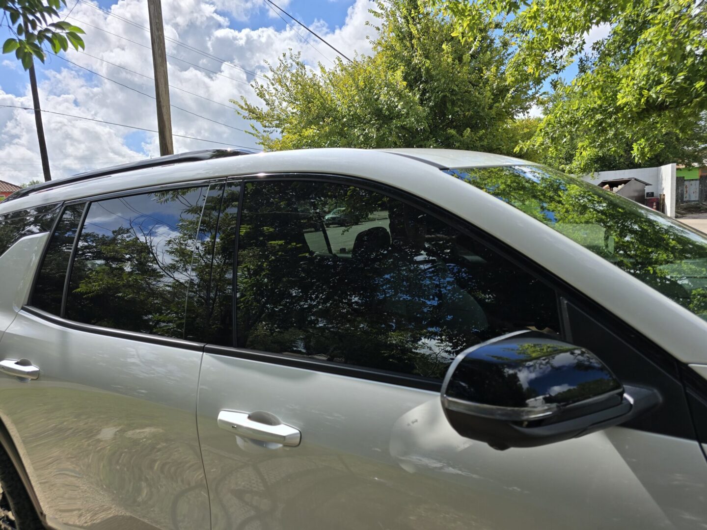 A car with its door open and the window glass broken.